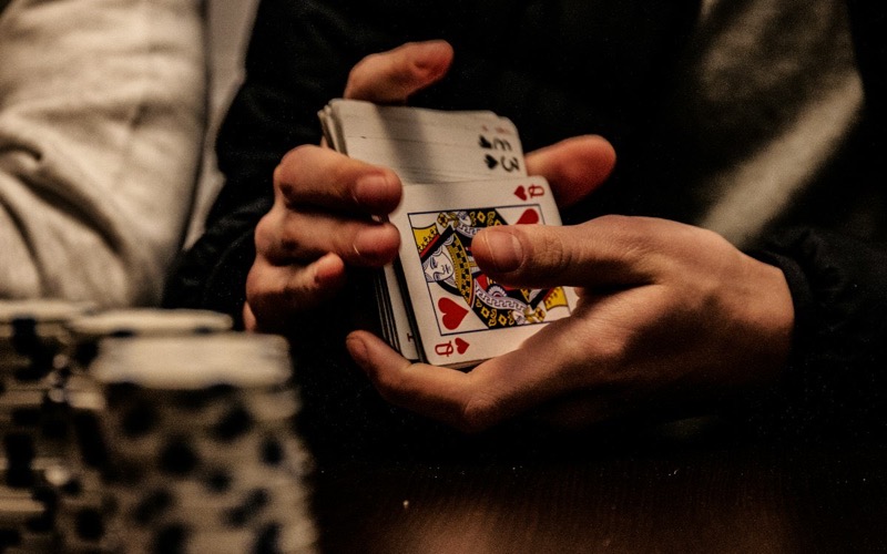 Sfeerbeeld (Unsplash): speelkaarten in de hand