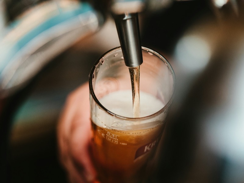 Sfeerbeeld (Unsplash): een glas wordt getapt