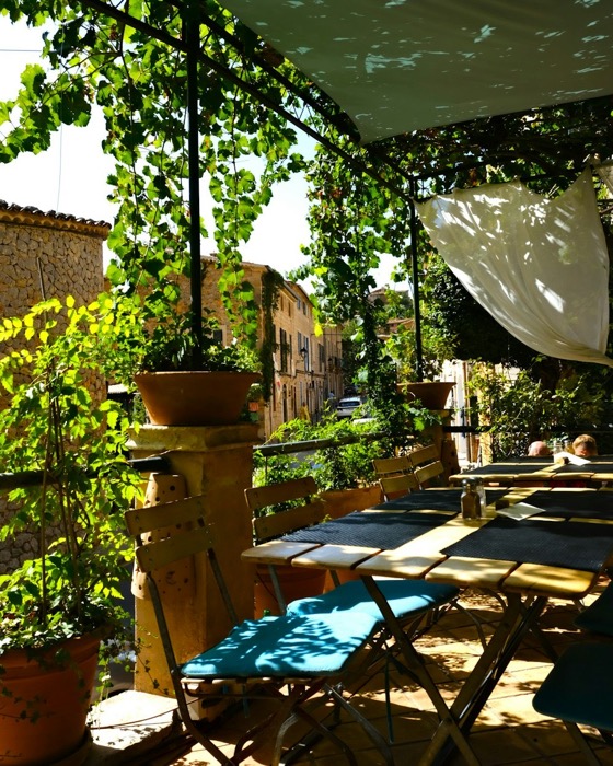 Sfeerbeeld (Unsplash): terras met tafels onder groen